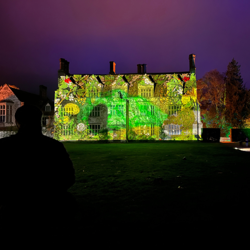 An old building fully lit up with an image projected onto it