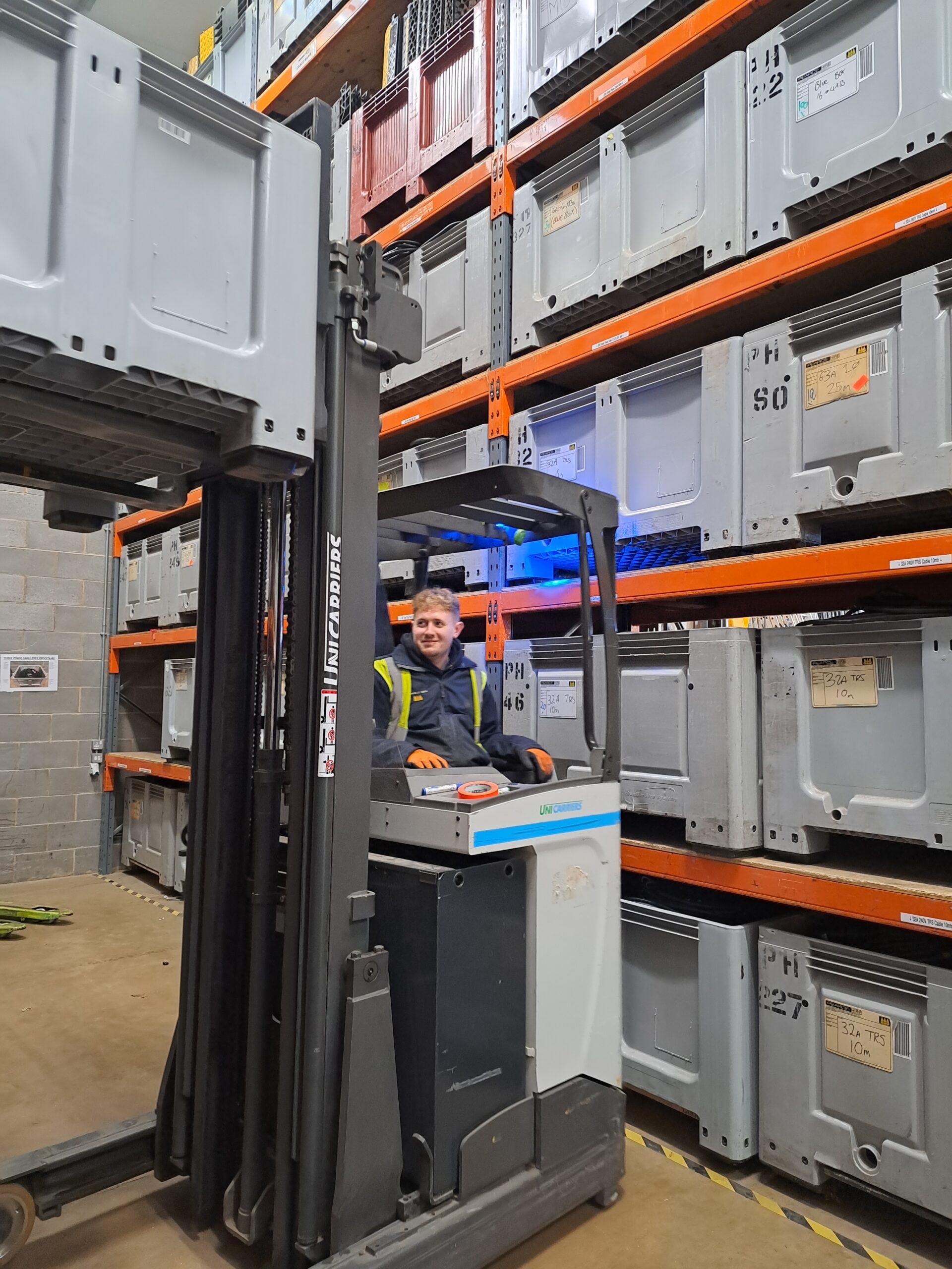 The warehouse supervisor forklifting a stillage onto the shelf
