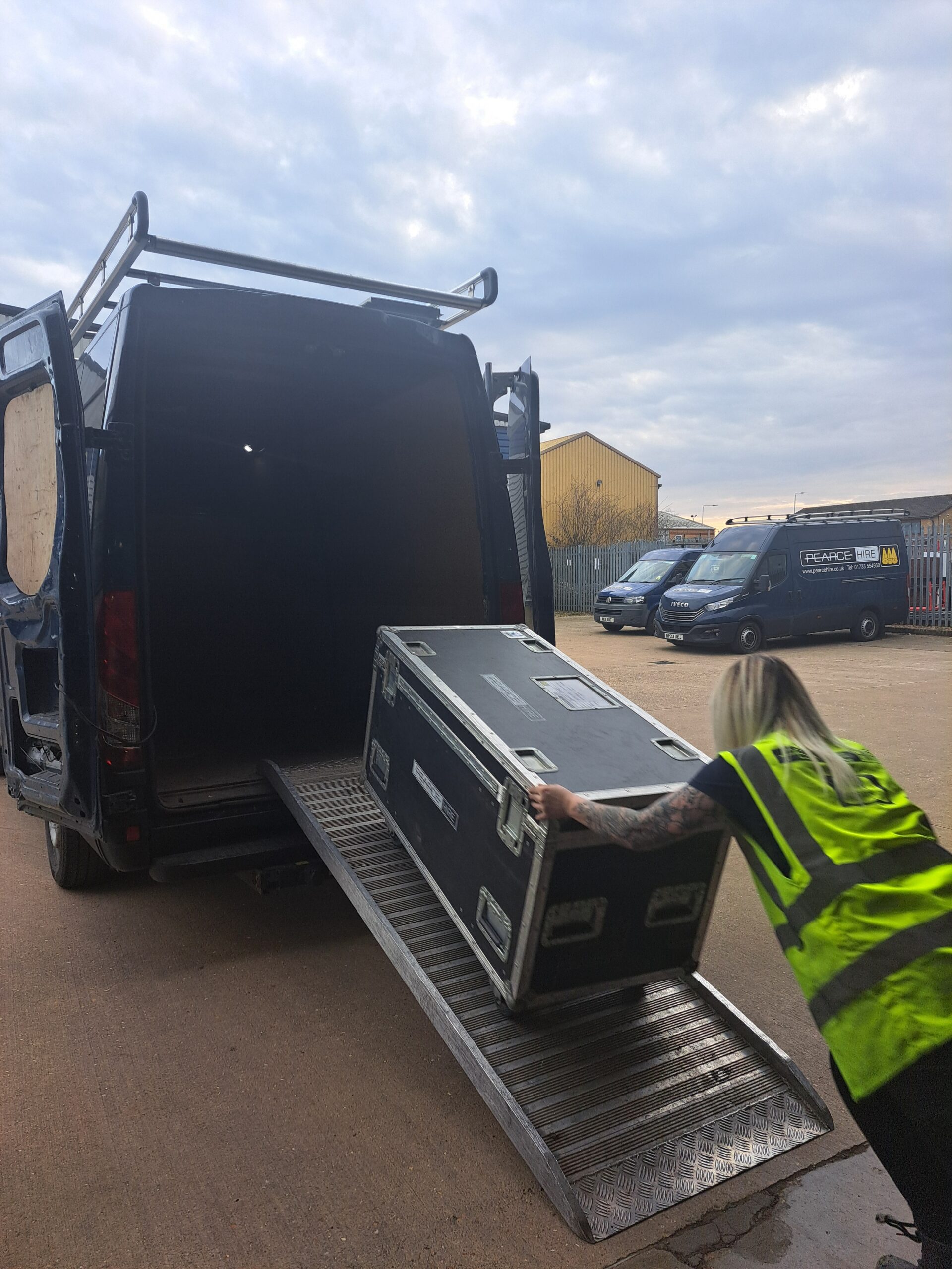Leanne loading the van with a flight case using a ramp
